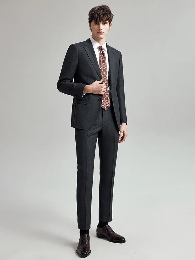 Model wearing the Borcelleclothes Men's Steel Grey Pinstriped Suit, lightly touching the front edge of the blazer to showcase the sharp silhouette and refined tailoring.