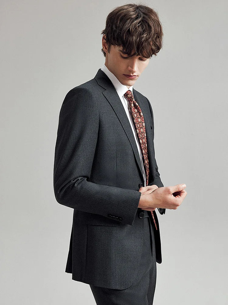 Model in the Borcelleclothes Men's Steel Grey Pinstriped Suit, gazing down at the sleeve, emphasizing the blazer's meticulous craftsmanship and pinstriped detail.