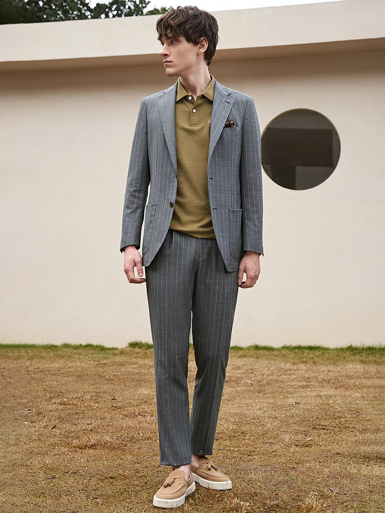 Model in Storm Grey suit and olive polo, turned to the side, where casual and tailored worlds meet. From Borcelleclothes.