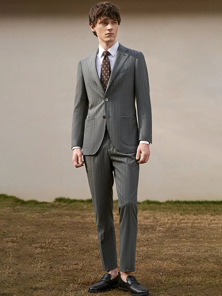 Model standing upright in Storm Grey wool suit, with sharp lines and commanding posture. From Borcelleclothes.