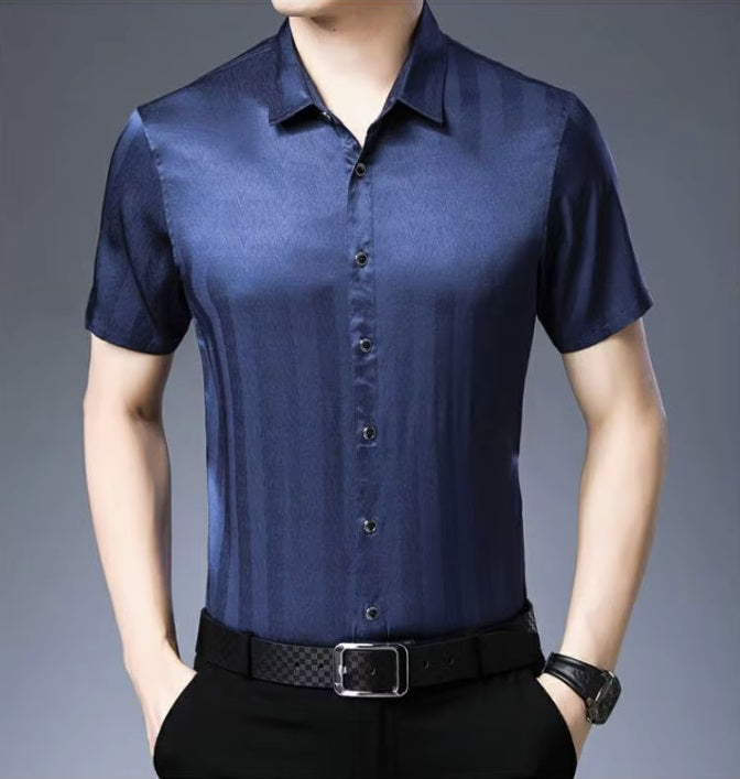 Men's Mulberry Silk Shirt from the Striped Collection in Dusky Blue, showcasing a refined minimalist design with subtle stripes that shift in visibility through the interplay of matte and glossy surfaces, highlighting its luxurious and dynamic quality. From Borcelleclothes.