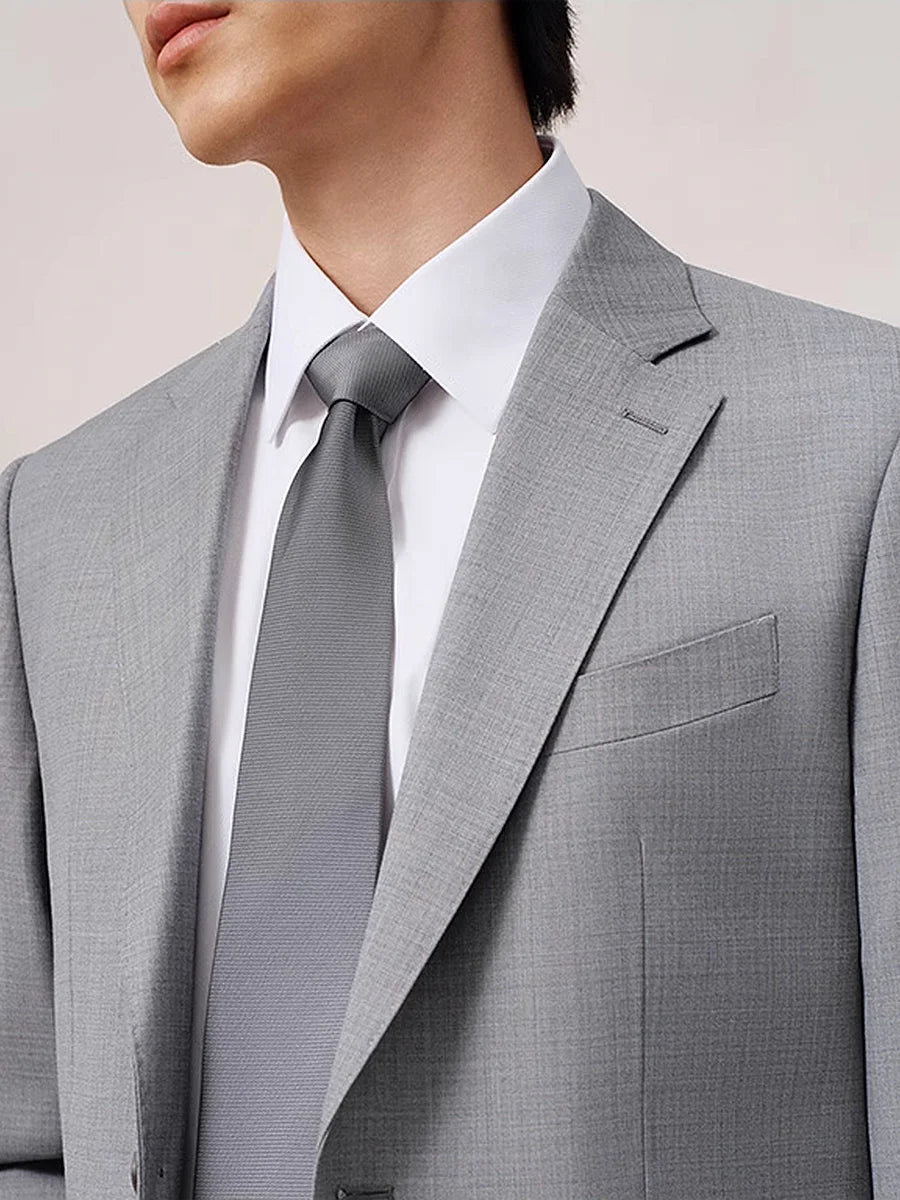 Upper part of the model in suit, highlighting the blazer’s lapel shape and button closure. From Borcelleclothes.