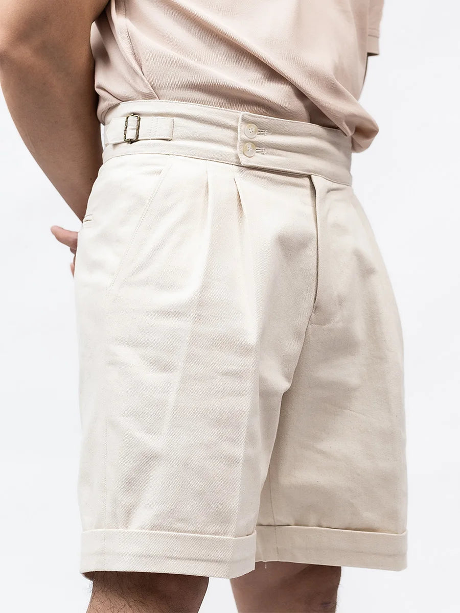 Model slightly turned to the side wearing Swiss Coffee tailored shorts, revealing their structured silhouette and refined construction. From Borcelleclothes.