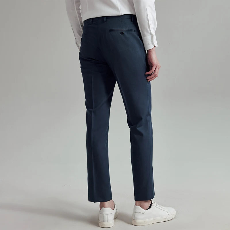 Back view of the model in River Bed trousers, emphasizing clean tailoring and double-welt pockets. From Borcelleclothes.