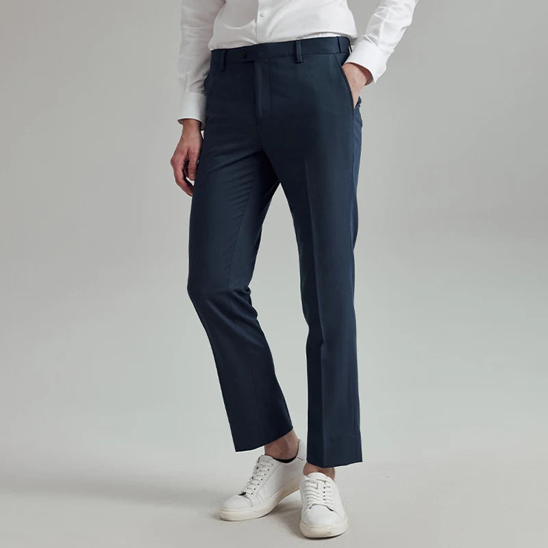 Model with hand in slash pocket, wearing River Bed cropped trousers with precise tailoring. From Borcelleclothes.