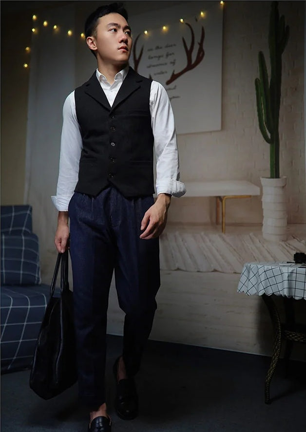 Model holds a black bag while wearing tailored denim trousers in Midnight Express, featuring contrast stitching and cropped length. From Borcelleclothes.