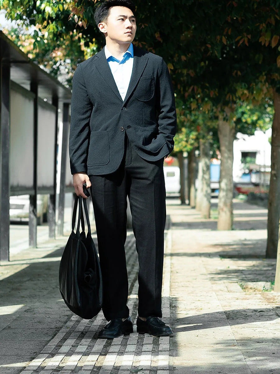 Model styled in tailored linen trousers in Onyx with a black blazer, blending formal structure with breathable fabric. From Borcelleclothes.