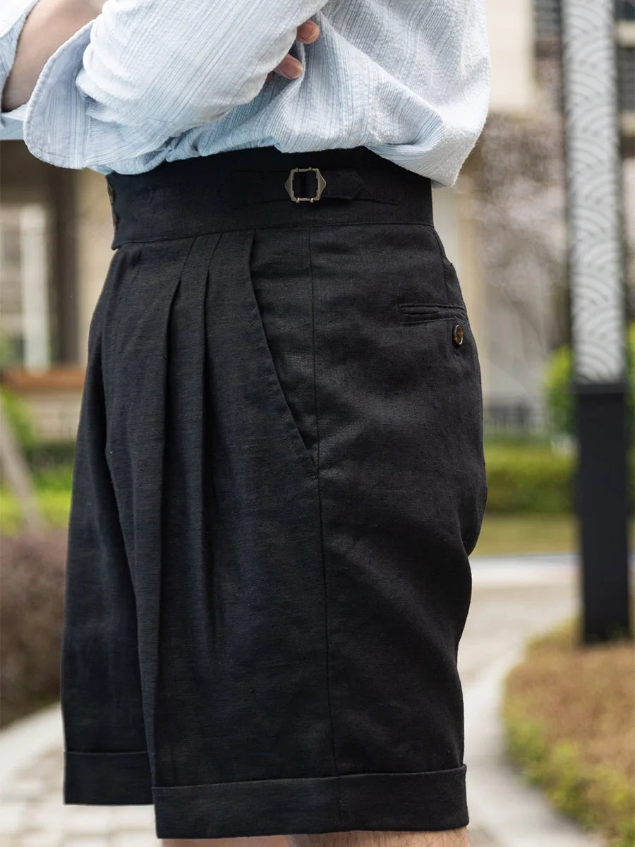 Model poses in onyx linen tailored shorts with arms crossed, projecting a composed and intentional presence. From Borcelleclothes.