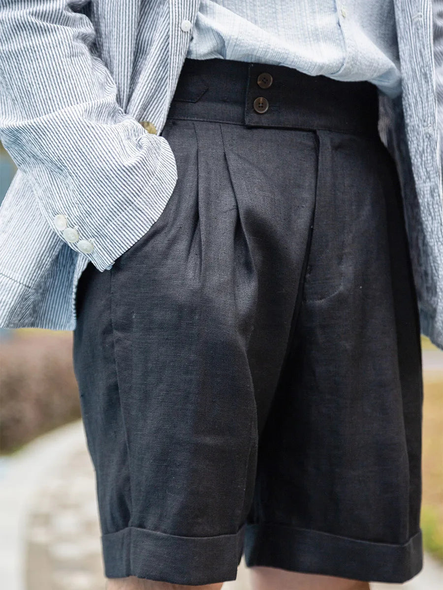 Model wears onyx linen tailored shorts with one hand placed in the pocket, highlighting the clean lines and structured fit. From Borcelleclothes.