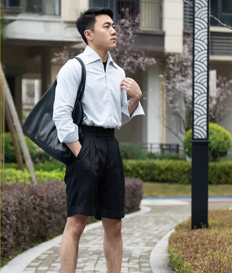 Side profile of the model in onyx linen tailored shorts, showcasing the precise cut and relaxed structure. From Borcelleclothes.