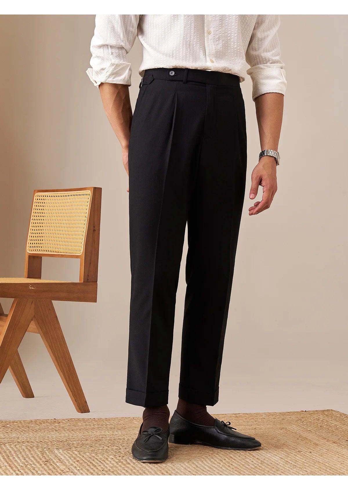 Model in Onyx trousers, standing with one foot angled outward, highlighting cropped hem and cuff. From Borcelleclothes.