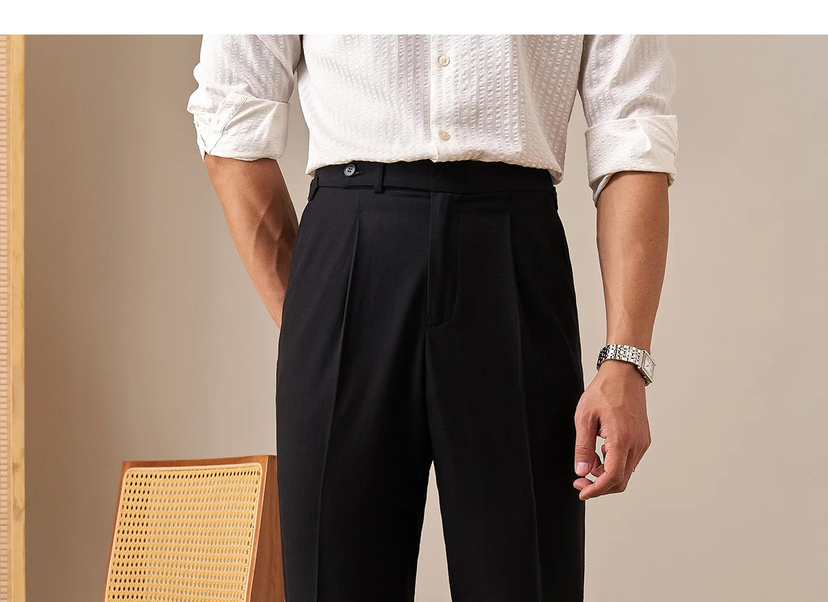 Men's straight wool-blend trousers in Onyx with two front tucks, adjustable side belts with buckles, clean waistband extension, and turned-back cropped cuffs. From Borcelleclothes.