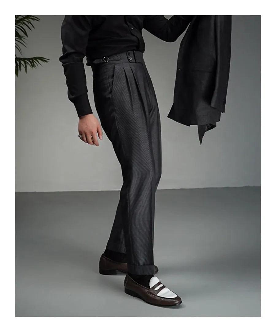 Model in Payne’s Grey trousers holding matching jacket in hand, styled with quiet confidence. From Borcelleclothes.