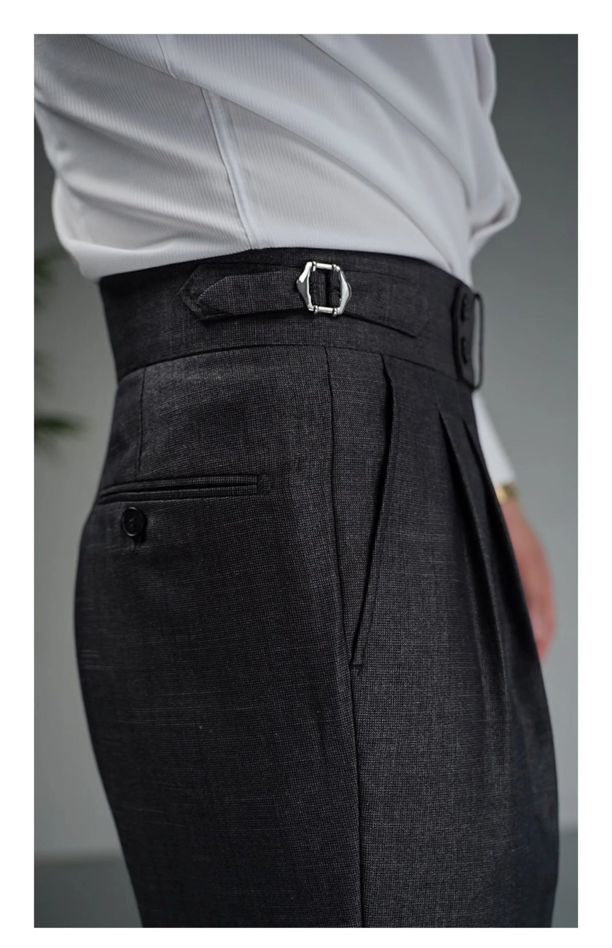 Close-up of upper right side of Payne’s Grey trousers showing structured waistband with double buttons and buckled side tab. From Borcelleclothes.