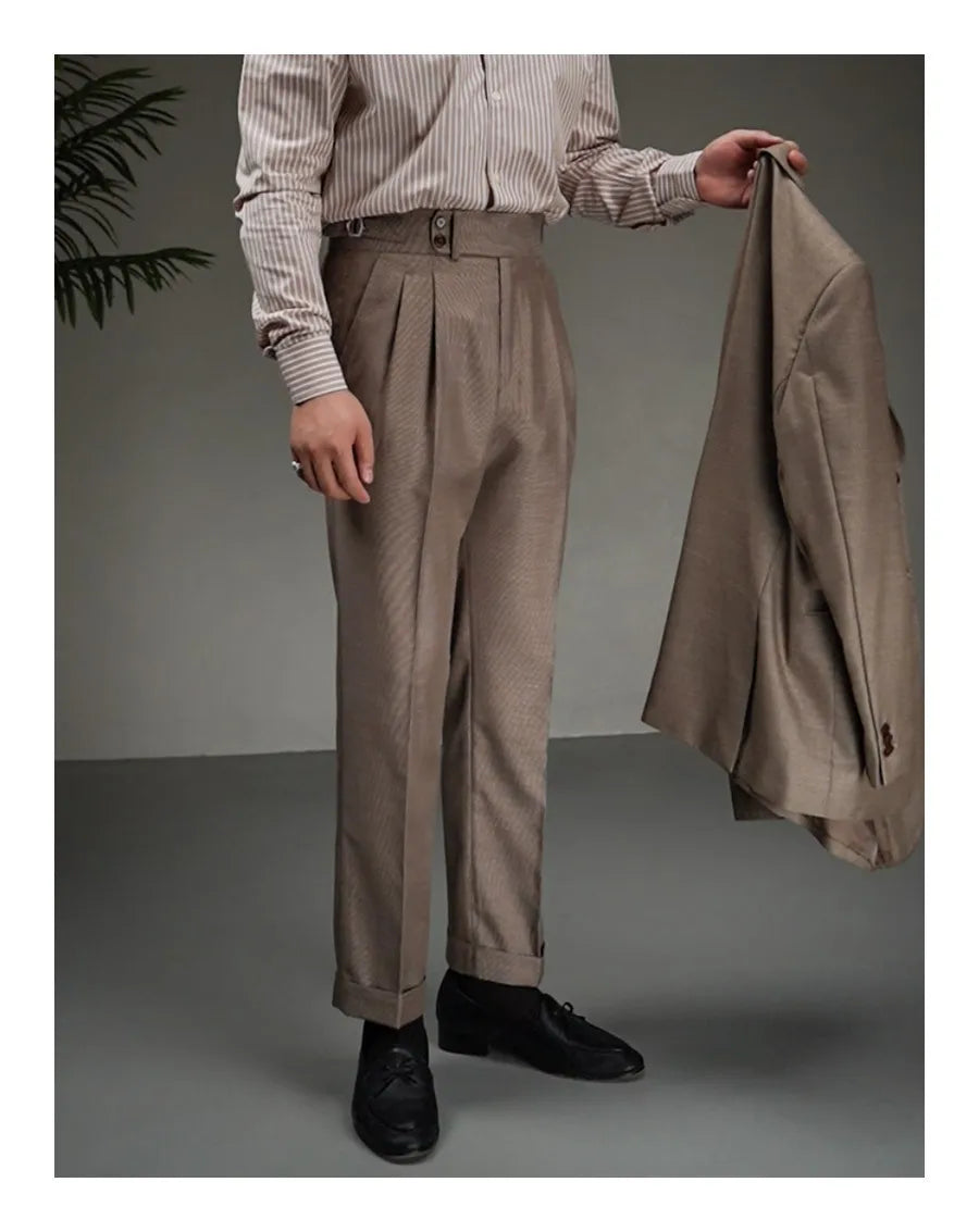 Model in Wenge trousers holding matching tailored jacket in hand, styled with controlled ease. From Borcelleclothes.