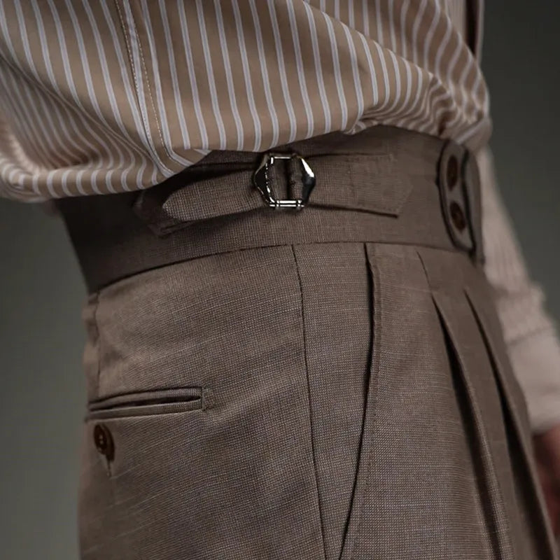 Close view of right waist section of Wenge trousers, showing buckled side belt and slash pocket. From Borcelleclothes.