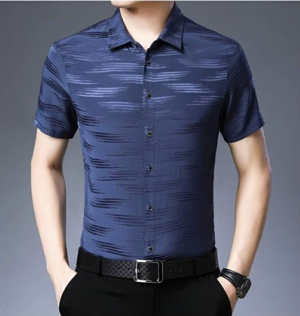 Men's Mulberry Silk Shirt from the Water Rippled Collection in Dusky Blue, featuring soft horizontal patterns that mimic the gentle movement of water ripples, enhanced by a play of matte and glossy finishes for a sophisticated, fluid look. From Borcelleclothes.