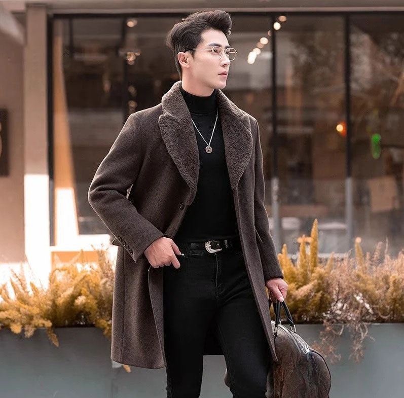 Men’s wool-cashmere coat with shearling peaked lapels in Wood Bark, model moving the right front aside to reveal a black turtleneck. From Borcelleclothes.