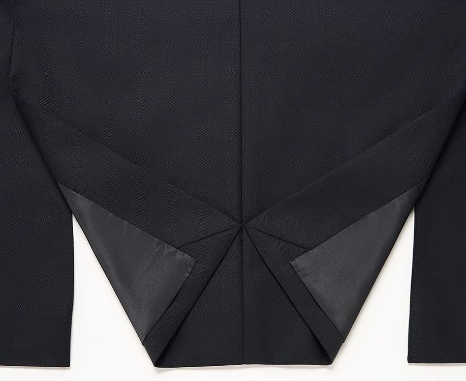 The folded back of the blazer from the Borcelleclothes Men's Wool and Silk Blend Suit in Onyx Texture, showcasing the double-vent detail for mobility and style.