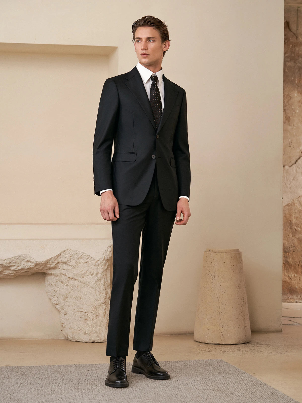 Model wearing the Borcelleclothes Men's Wool and Silk Blend Suit in Onyx Texture, standing with arms straight to showcase the suit's tailored fit and clean silhouette.