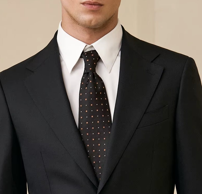 The upper part of the Borcelleclothes Men's Wool and Silk Blend Suit in Onyx Texture, focusing on the notch lapels and clean chest pocket design.