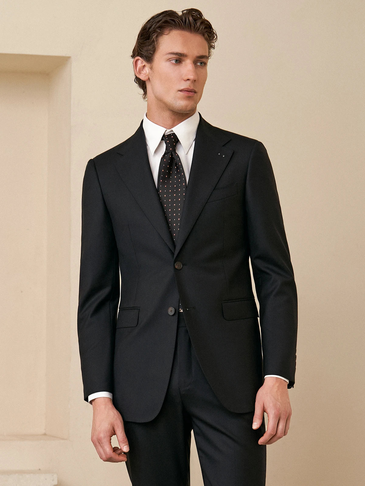 Model dressed in the Borcelleclothes Men's Wool and Silk Blend Suit in Onyx Texture, looking to the side, highlighting the sharp tailoring and modern design.