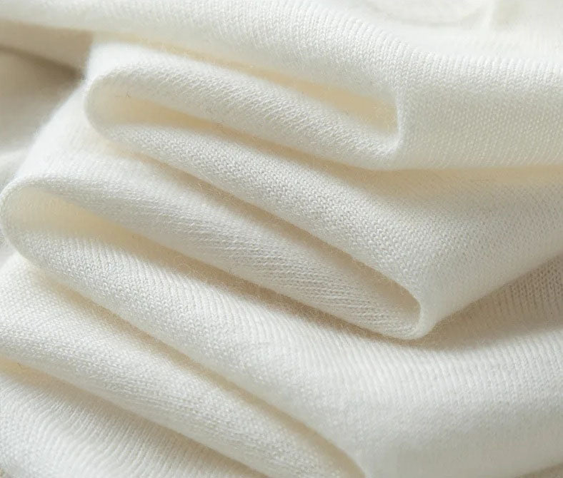 Platinum-colored worsted cashmere sweater folded to highlight the smooth surface and soft drape of the fabric — From Borcelleclothes.