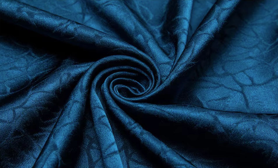 Mulberry silk fabric in Chathams Blue with an earth-inspired pattern, demonstrated by being held and released to showcase its qualities and fluidity. From Borcelleclothes.