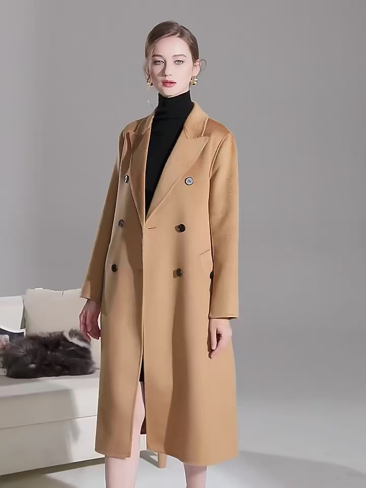 Video showcasing a Women's Double-Sided Wool-Cashmere Coat in Brown Sugar and Bourbon, showcasing luxurious peaked lapels, a straight silhouette, and meticulously tailored details like single-welt pockets with buttonholes, crafted from a premium wool-cashmere blend for warmth and refinement. From Borcelleclothes.