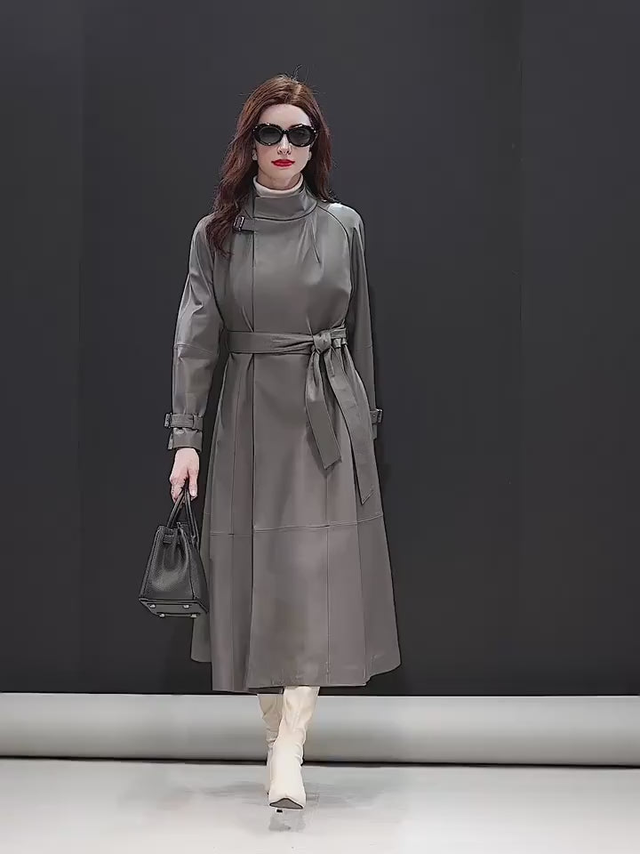 Video showcasing a Women's Avant-Garde Wrap Coat in Monsoon. Model holds a structured handbag, highlighting the coat’s sophisticated drape and commanding elegance. Borcelleclothes.