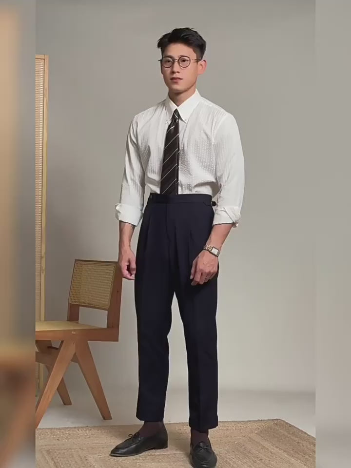 Video showcasing a Men's straight wool-blend trousers in Onyx with two front tucks, adjustable side belts with buckles, clean waistband extension, and turned-back cropped cuffs. From Borcelleclothes.