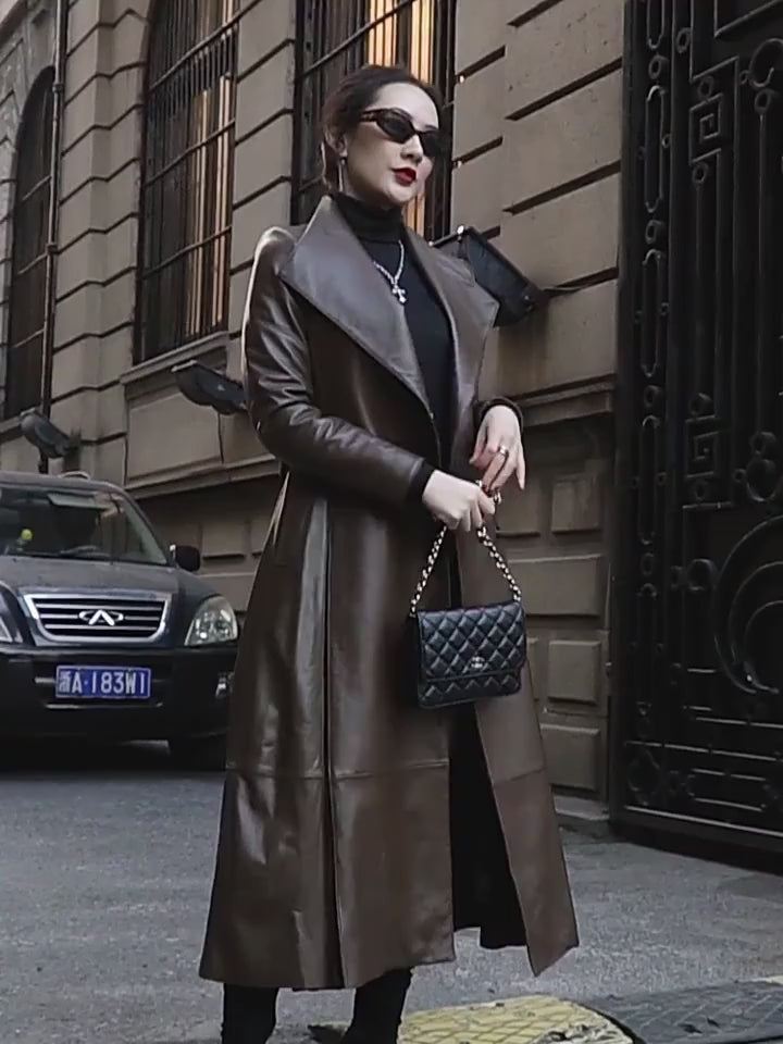 Video showcasing a Women's Flowing Leather Coat in Taupe. Crafted from genuine sheepskin, featuring inverted box pleats with nested knife pleats, a structured lapel collar, and a self-tie belt for defined elegance and unrestricted movement. Borcelleclothes.