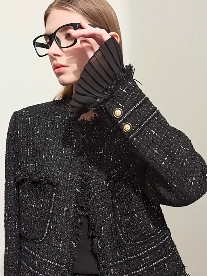 Video showcasing a Women’s cropped tweed jacket in Onyx and Platinum, with fringed edges, gold lurex threads, patch pockets, and detachable sheer pleated cuffs – From Borcelleclothes.