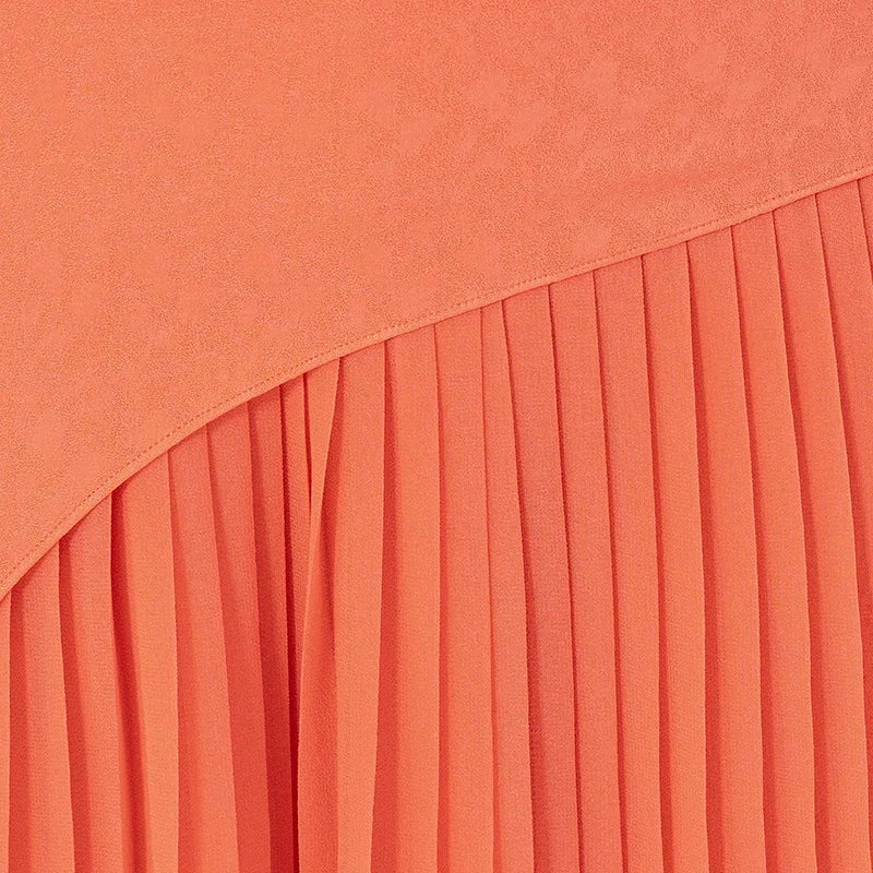 Detailed view of the sloping georgette pleats on a women's layered asymmetrical Mulberry silk skirt in Veiltail Gold — From Borcelleclothes.