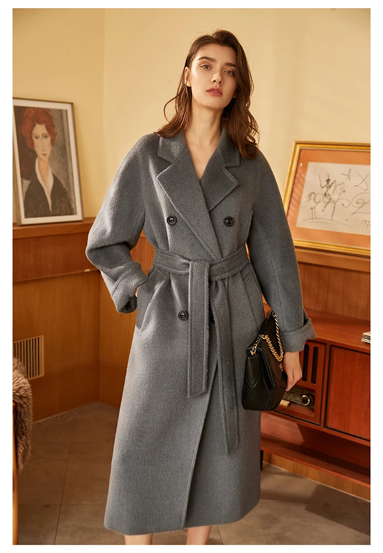 Model wearing the Women’s Mid-Calf Alpaca Coat in Carbon Grey with a hand in the pocket, emphasizing its tailored design and plush alpaca fabric. From Borcelleclothes.