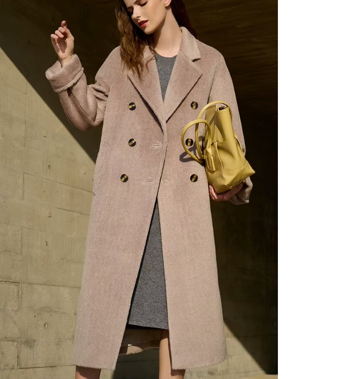 Model wearing the Women’s Mid-Calf Alpaca Coat in Quicksand, holding a bag, showcasing the coat’s warm hue and stylish versatility. From Borcelleclothes.