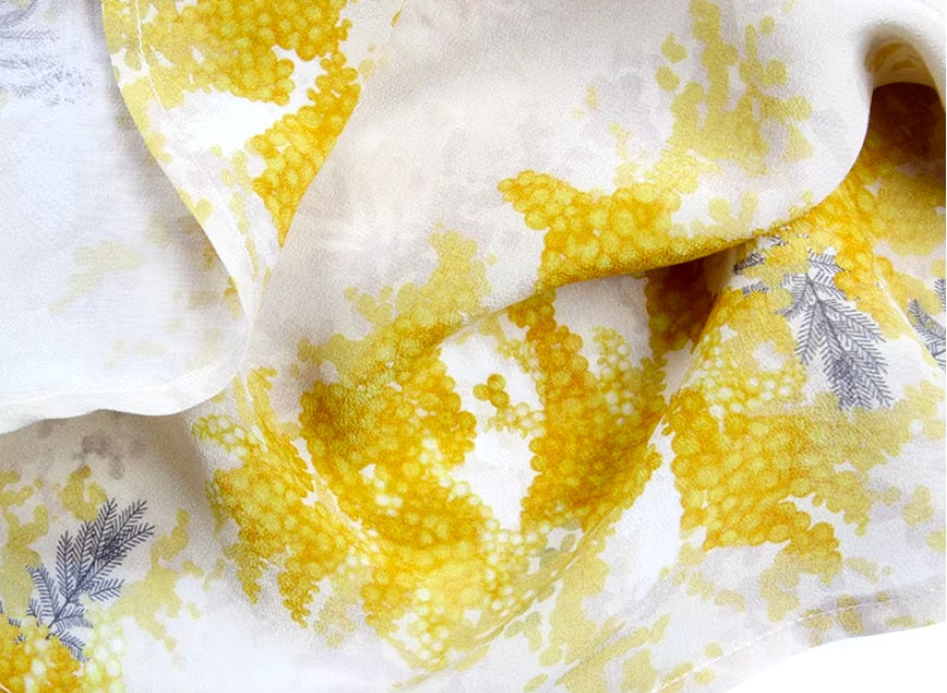 Detailed stitching and textured fabric on the bottom of a Women's 100% Mulberry Silk Shirt with Mimosa Print in Dawn Pink, featuring contrast collar, bold accents, and a flowing silhouette. From Borcelleclothes.