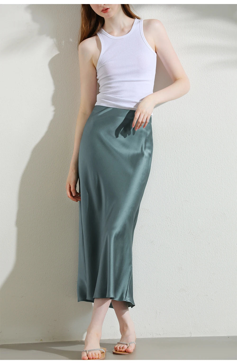 Model in Blue Bayoux silk skirt gently touching front waistband, showing controlled softness and structure. From Borcelleclothes.