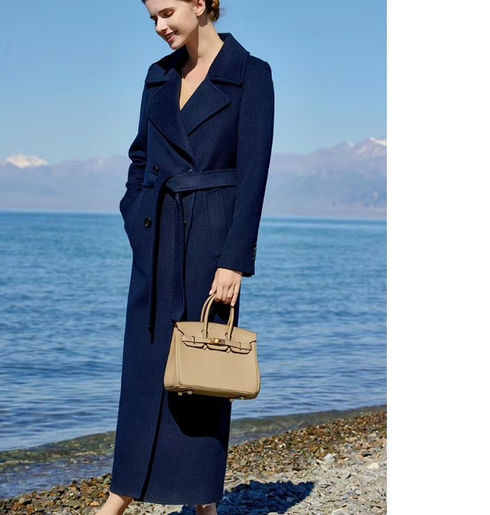 Model wearing the Women's 7/8 Cashmere Blend Coat in Deep Cove, holding a bag, showcasing its dramatic 7/8 length and sophisticated silhouette. From Borcelleclothes.