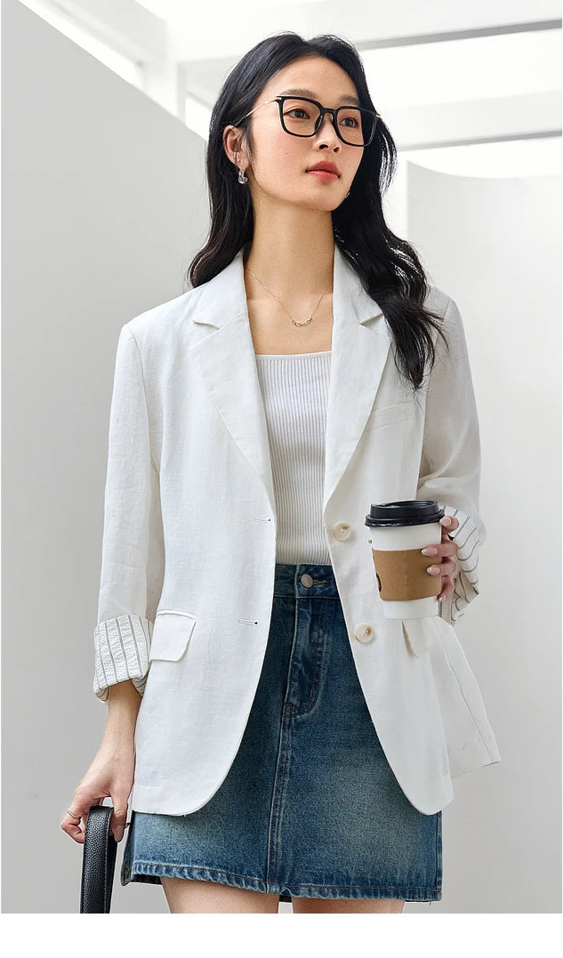 Woman in Alabaster Urban Blazer holding a cup of coffee and a bag. From Borcelleclothes.