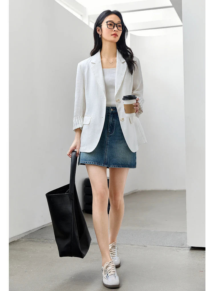 Woman in Alabaster Urban Blazer carrying an oversized bag and a cup of coffee. From Borcelleclothes.