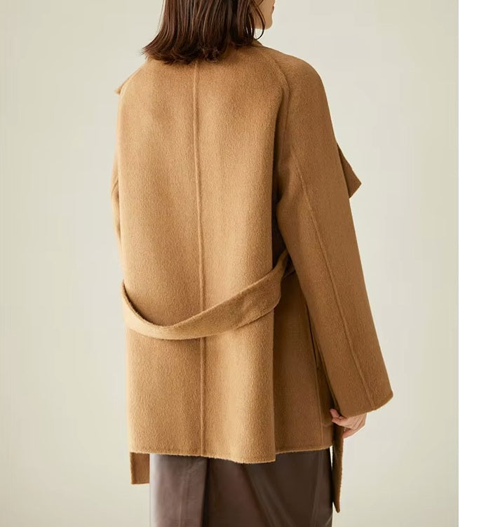 Back of the Women's Asymmetrical Camel Hair Coat in Bourbon, showcasing its flowing drape, raglan sleeves, and sculpted silhouette. From Borcelleclothes.