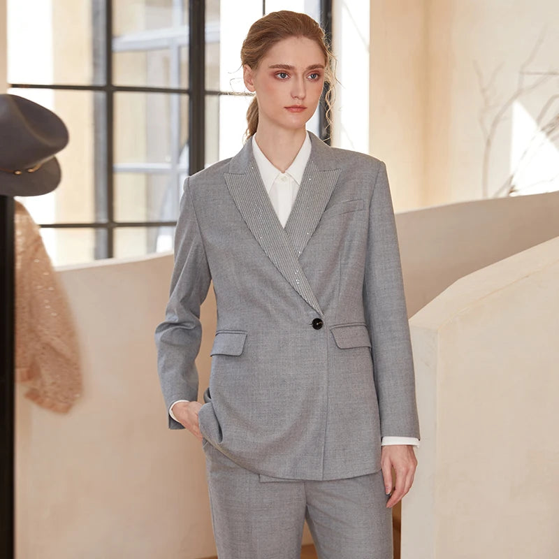 Women’s Australian wool blazer in Mountain Mist with chain detail, model with hand in pants pocket. From Borcelleclothes.