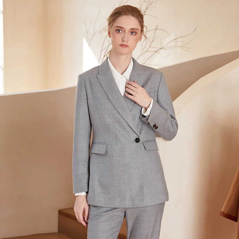 Women’s Australian wool blazer in Mountain Mist, with chain detail, peaked lapels, single horn button, and high-set flap pockets — formal codes reimagined with feminine balance. From Borcelleclothes.