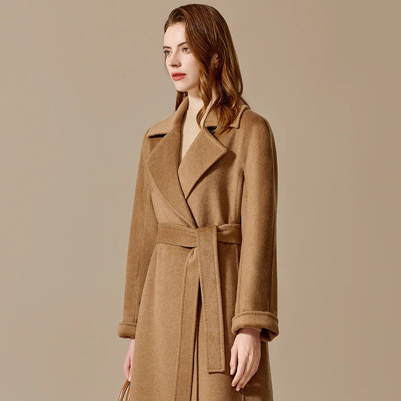 A model wearing the Women's Bactrian Camel Hair Coat in Santa Fe, turned slightly to the side, showcasing its tailored fit and flowing silhouette. From Borcelleclothes.