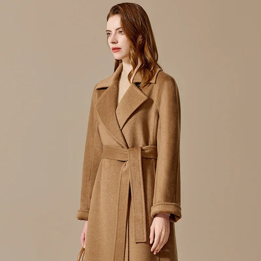 A model wearing the Women's Bactrian Camel Hair Coat in Santa Fe, turned slightly to the side, showcasing its tailored fit and flowing silhouette. From Borcelleclothes.