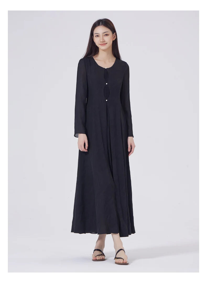 Model wearing the Baltic Sea silk dress with legs gently crossed, showing fabric movement. From Borcelleclothes.