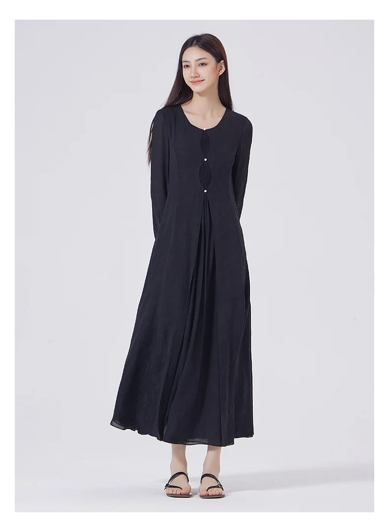 Model with hands behind back, showcasing the dress's front tuck panel and graceful silhouette. From Borcelleclothes.