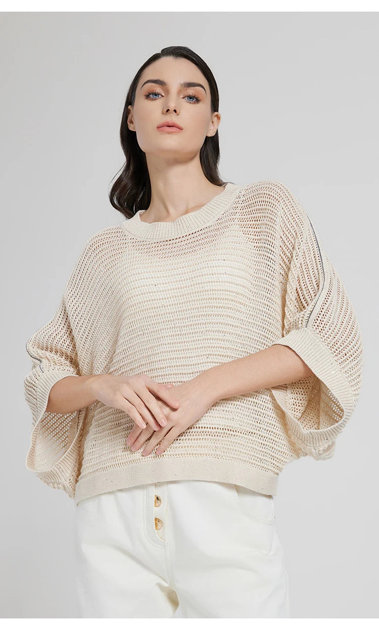 Woman wearing Spring Wood batwing mesh top, hands softly meeting in front, sleeves draping with quiet ease. From Borcelleclothes.