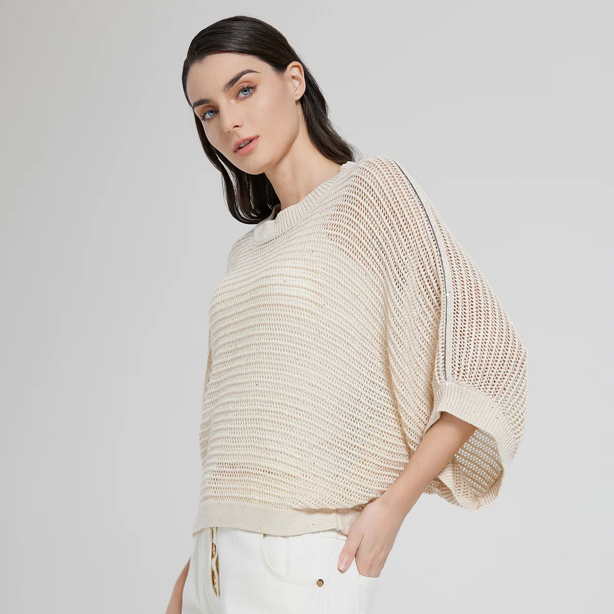 Woman in Spring Wood batwing linen mesh top, turned slightly to the side, mesh loops softly catching the light. From Borcelleclothes.